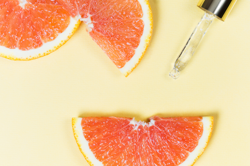 Cosmetic Solutions Trends Report Webinar Image features a dropper on a yellow background among slices of citrus skin care ingredients